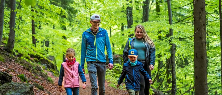 Eine Frau und ein Mann laufen zusammen mit zwei Kindern auf einem Weg durch den Wald | © Bodenmais Tourismus & Marketing GmbH