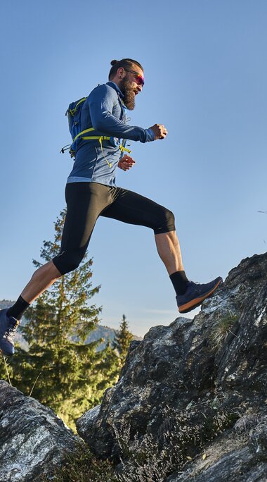 Ein Trailrunner springt von einem Fels auf einen anderen. | © Bodenmais Tourismus & Marketing GmbH