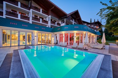 Blick über den beleuchteten Außenpool auf das Hotel. | © Bodenmais Tourismus & Marketing GmbH