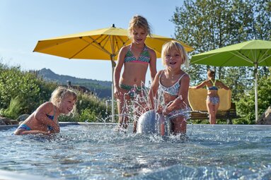 Drei Mädchen spielen im Freibad in einem Wasserbecken. | © Bodenmais Tourismus & Marketing GmbH