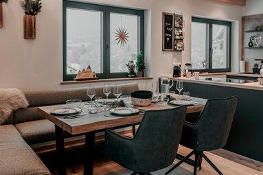 In einem modernen aber gemütlich eingerichtetem Wohnraum steht ein gedeckter Tisch. | © Bodenmais Tourismus & Marketing GmbH