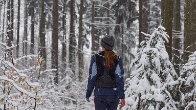 Frau wandert durch den verschneiten Wald | © Bodenmais Tourismus & Marketing GmbH