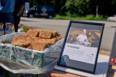 In einer Schachtel liegen Müslirigel. Daneben steht ein Foto mit Beschreibungstext zum Bäcker. | © Bodenmais Tourismus & Marketing GmbH