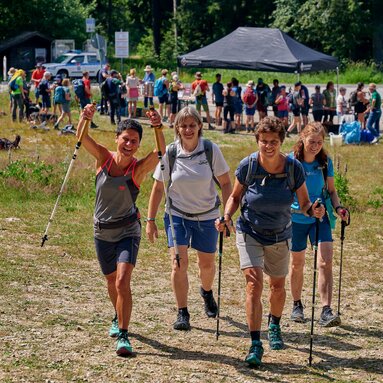 Vier Teilnehmerinnen wandern zusammen weiter, während hinter ihnen noch einige Teilnehmer an der Versogungsstation stehen. | © Bodenmais Tourismus & Marketing GmbH