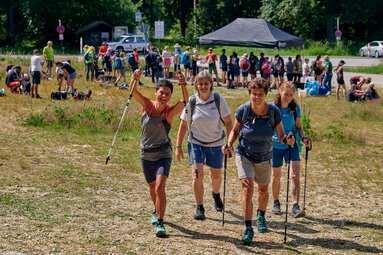 Vier Teilnehmerinnen wandern zusammen weiter, während hinter ihnen noch einige Teilnehmer an der Versogungsstation stehen. | © Bodenmais Tourismus & Marketing GmbH