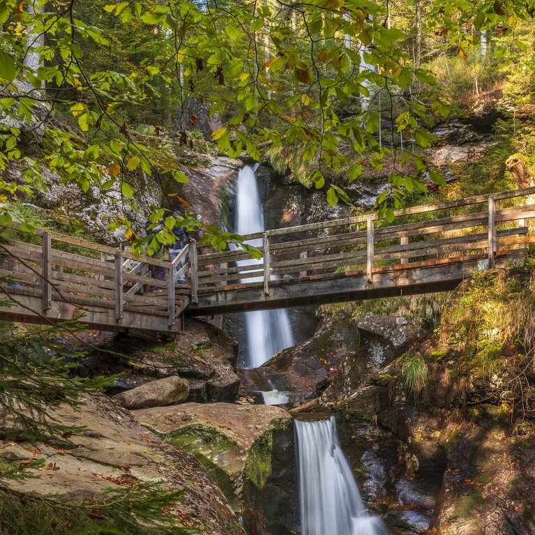 Man sieht den Wasserfall "Hochfall" in seiner vollen Pracht. Circa auf halber Höhe führt eine Brücke über den Wasserfall. | © Bodenmais Tourismus & Marketing GmbH