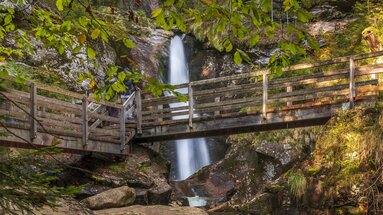 Man sieht den Wasserfall "Hochfall" in seiner vollen Pracht. Circa auf halber Höhe führt eine Brücke über den Wasserfall. | © Bodenmais Tourismus & Marketing GmbH