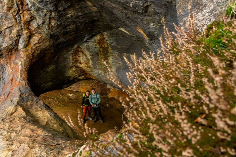 Ein Paar steht in einer Höhle am Silberberg und schaut durch den ausgehöhlten Stein nach oben. | © Bodenmais Tourismus & Marketing GmbH