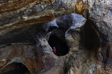Ein Kind steht in einer Höhle am Silberberg und blickt durch den ausgehöhlten Stein nach oben. | © Bodenmais Tourismus & Marketing GmbH
