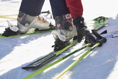 Nahaufnahme eines Skifahrers, der seine Stöcke vom Boden aufhebt. | © Bodenmais Tourismus & Marketing GmbH