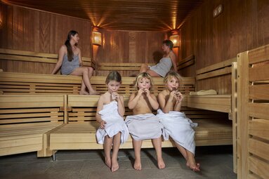 Zwei Frauen und drei Kindern sitzen zusammen in einer Sauna | © Bodenmais Tourismus & Marketing GmbH