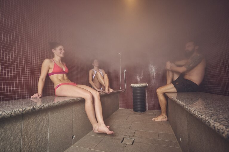 Zwei Frauen und eine Mann sitzen in Badekleidung in einem Dampfbad. | © Bodenmais Tourismus & Marketing GmbH