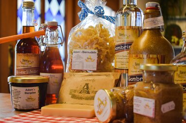 Auf einem Tisch sind verschiedene, unter anderem bierige, Spezialitäten aufgestellt, wie Marmeladen, Käse, Schnaps, Bier und so weiter. | © Bodenmais Tourismus & Marketing GmbH